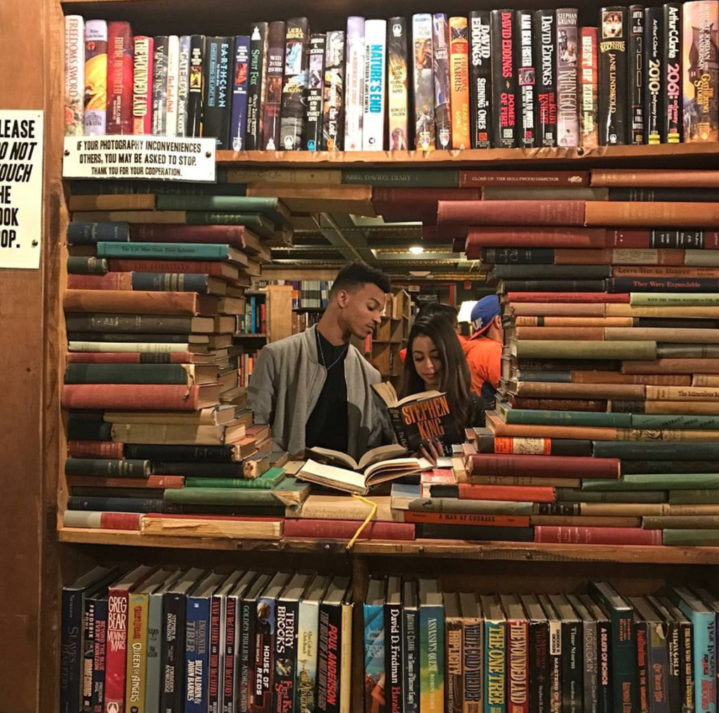 couple poses at The Last Bookstore in DTLA
