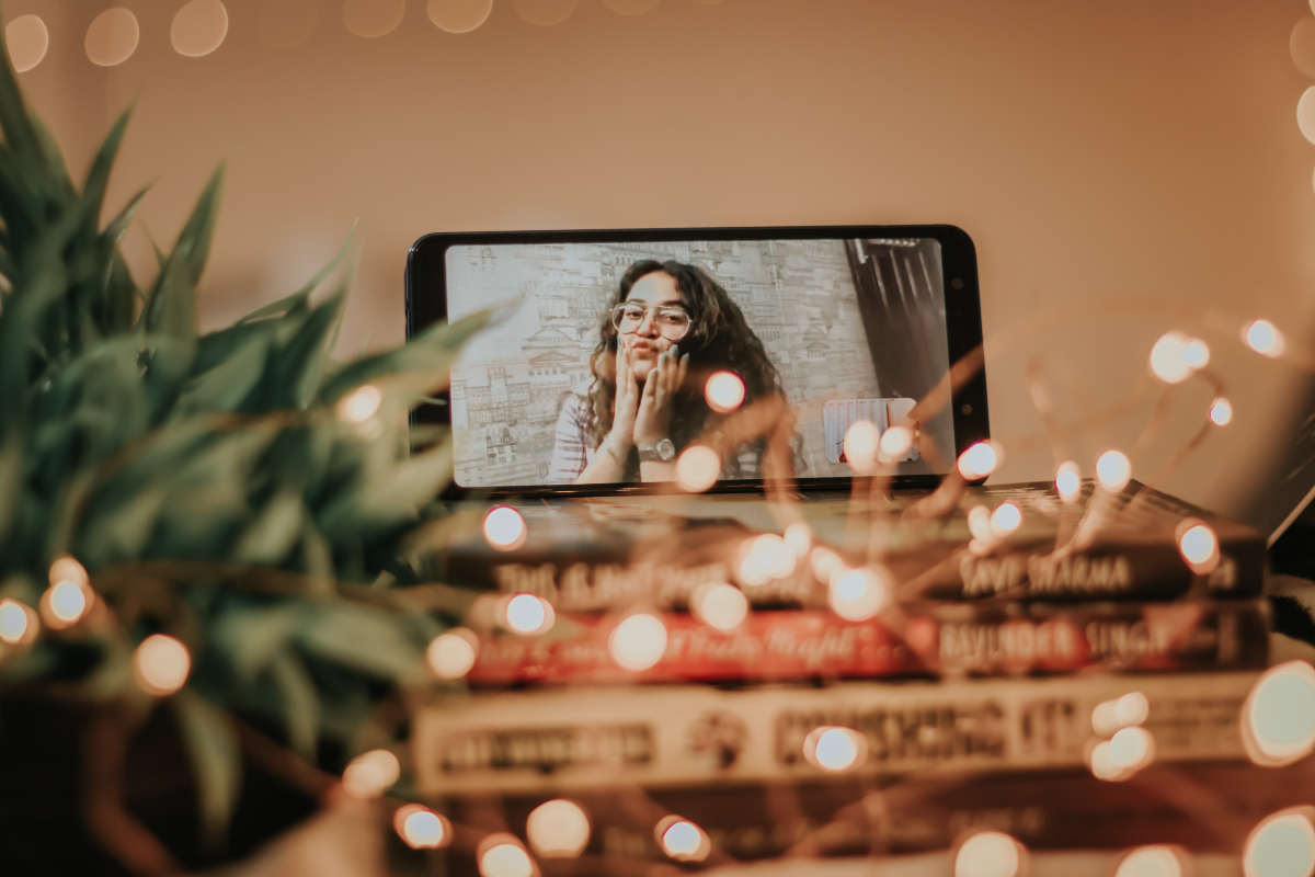 Woman on FaceTime with string lights surrounding phone