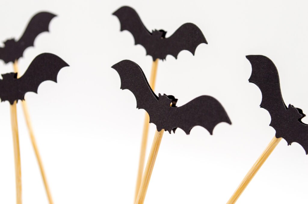cutout black paper bats pasted on sticks for fall decor
