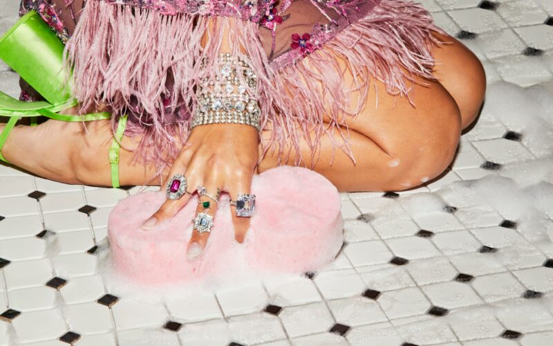 diamond drunk lifestyle image girl wearing gaudy jewelry sitting on a tile floor scrubbing