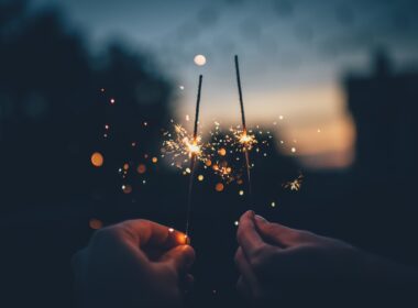 two hands use sparklers to celebrate the new year and think about 2024 goal planning